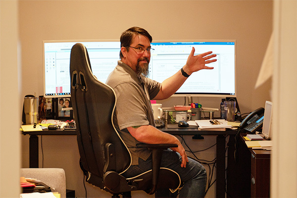 accountant waving from his computer