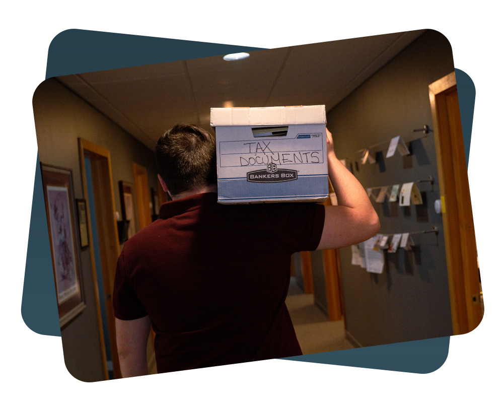 accountant holding a box labeled "tax documents"