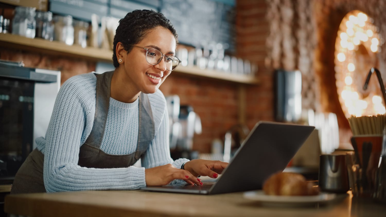 Young and Beautiful Latina Coffee Shop Owner is Working on Lapto young and beautiful latina coffee shop owner is working on lapto