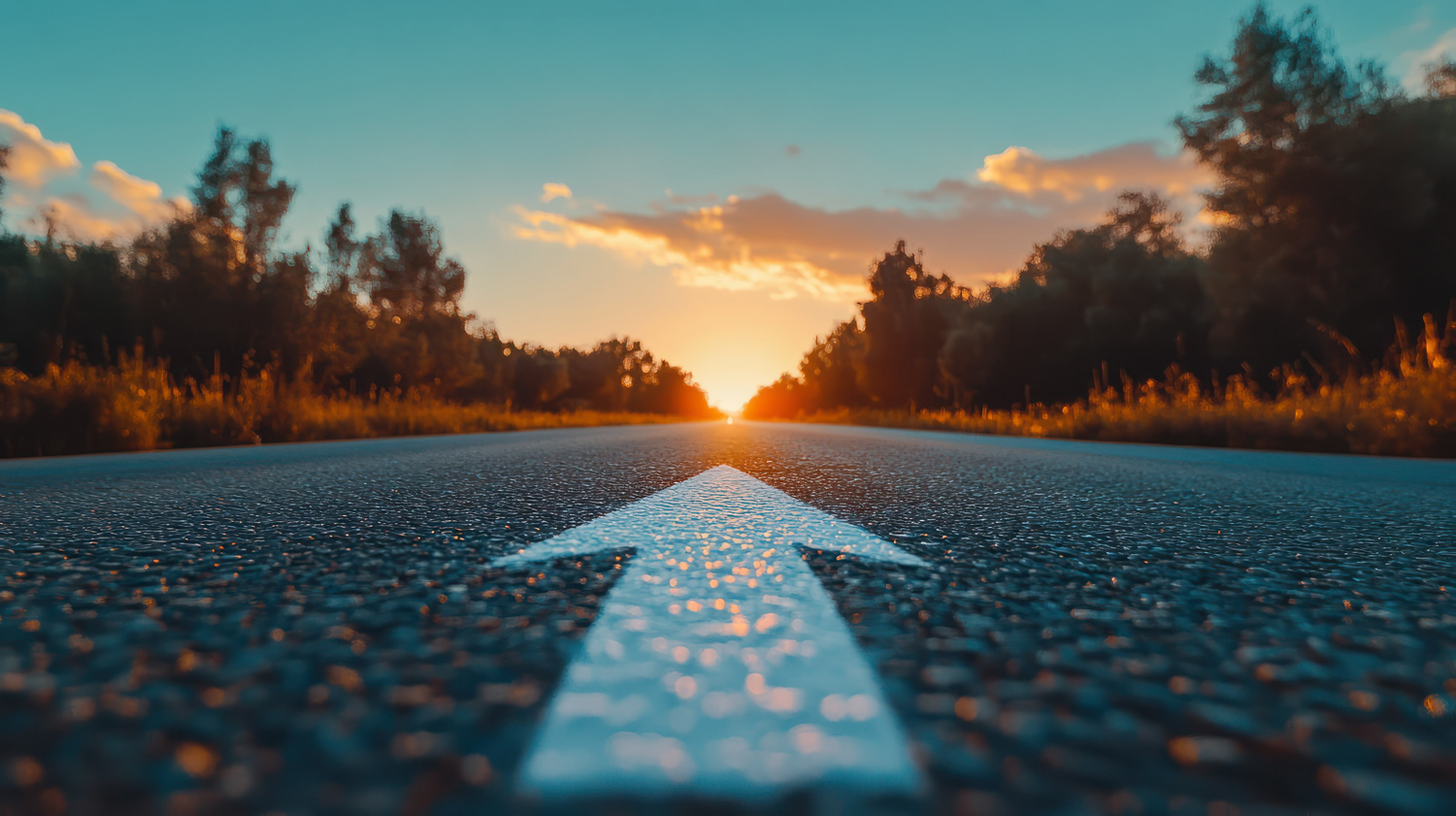 low angle photography of a white arrow on the asphalt road durin